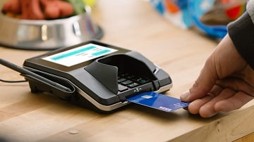 Person using Visa chip card at a chip-enabled terminal.