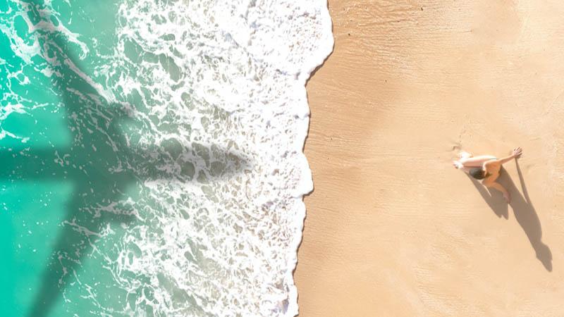 The shadow of a plane falls on a sunny beach