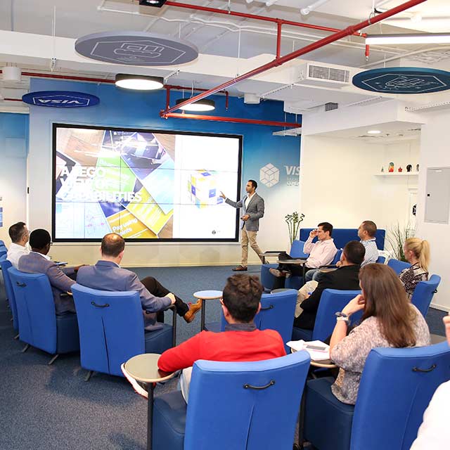 A Visa employee using a big screen display for a presentation in the Collaboration Space.